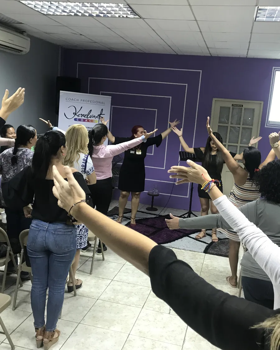 Participantes con las manos en alto durante un taller